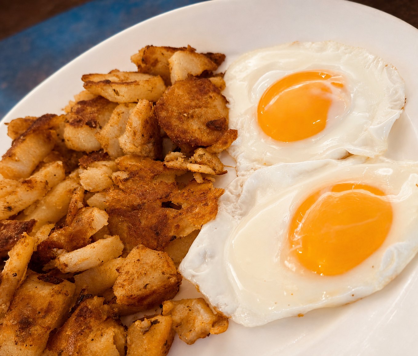 Two sunny-side-up eggs with home fries