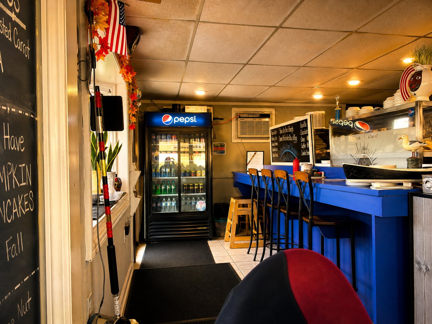 The small, cozy blue-toned interior of Castaways with the counter