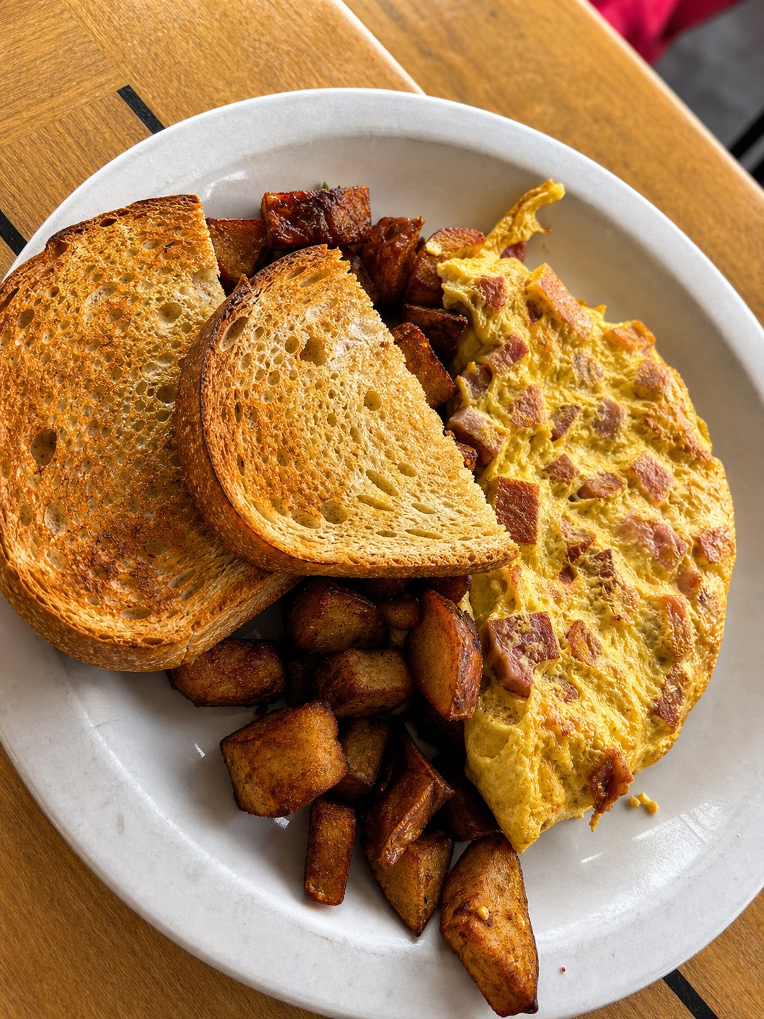An omelette with a toasted bagel and home fries